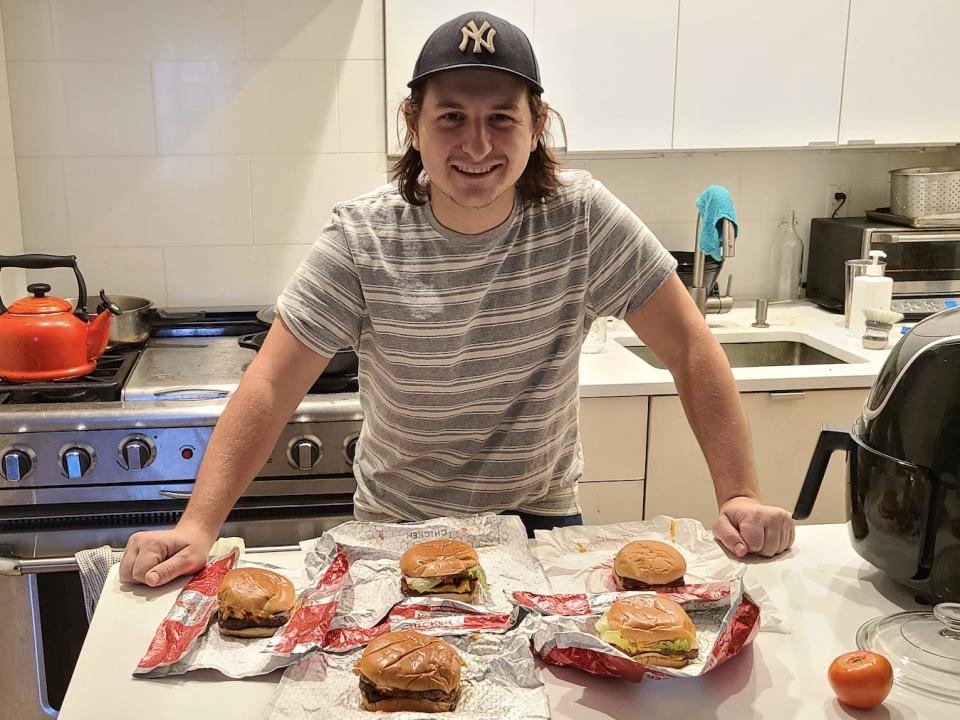 write posing in kitchen with wendys burgers laid out on white counter