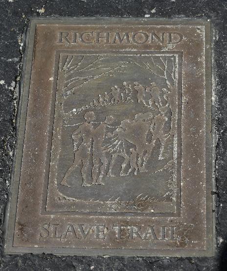 A historical marker is embedded in the walkway near the Lumpkin Jail historical site at the Slave Burial GroundMonday, March 31, 2014. A proposal to build a minor league baseball stadium in Shockoe Bottom, the city’s oldest neighborhood and the center of the once-thriving slave trade, has drawn criticism from some who believe the area is sacred ground and shouldn’t be bulldozed for a ballpark. The city says it will recover and display artifacts related to the slave trade.(AP Photo/Steve Helber)