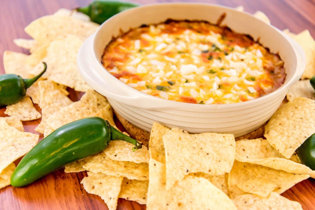 hot layered bean dip with jalapenos, sour cream and melted cheddar cheese