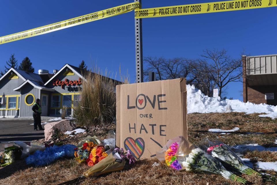 Bouquets of flowers and a sign reading "Love Over Hate" are left near Club Q, an LGBTQ nightclub in Colorado Springs, Colorado, on Nov. 20, 2022.