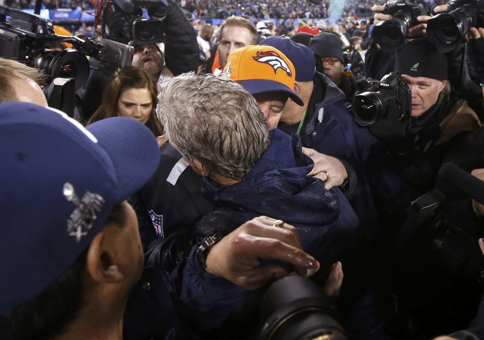 Seattle Seahawks head coach Carroll hugs Denver Broncos head coach Fox after Seattle defeated Denver in the NFL Super Bowl XLVIII football game in East Rutherford, New Jersey