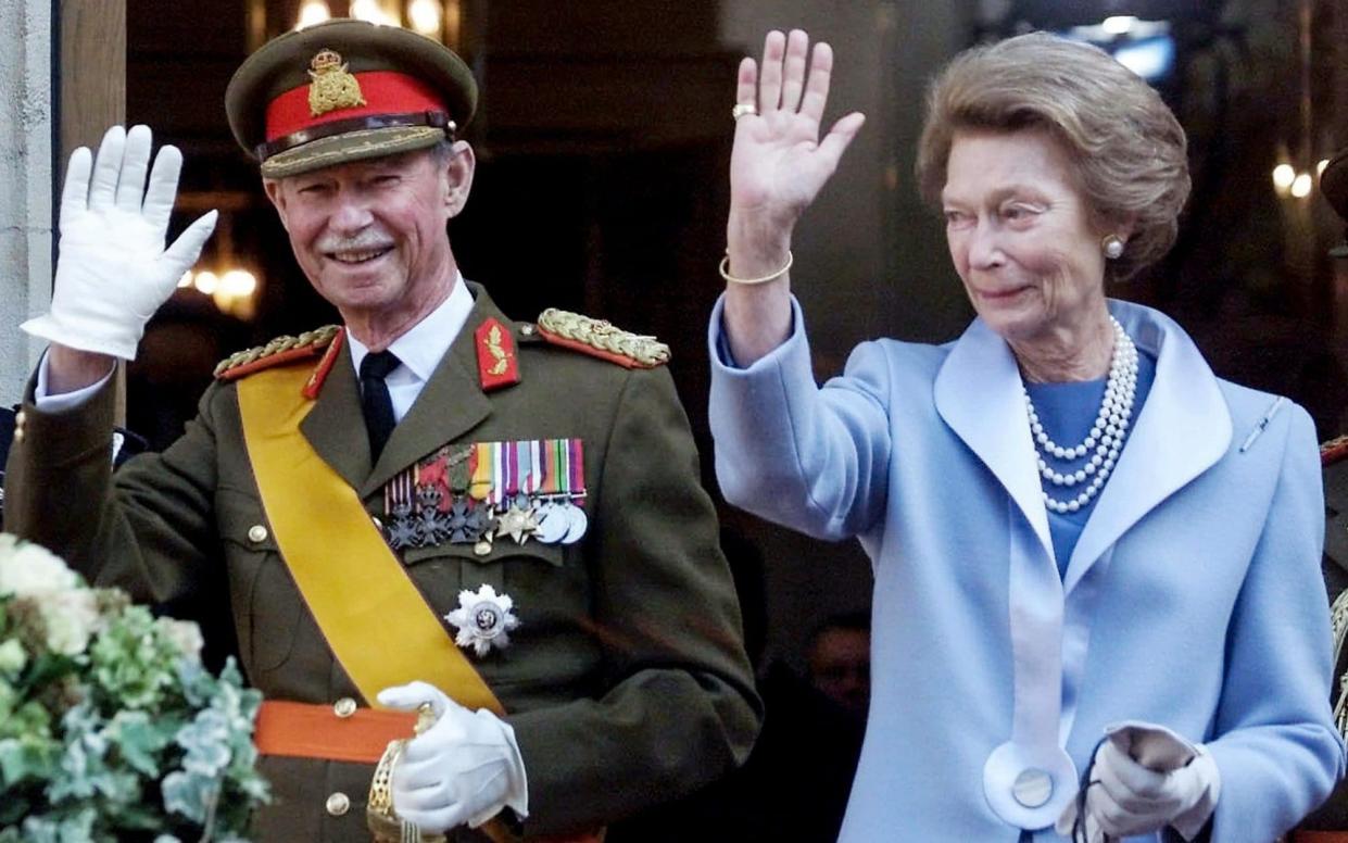 Grand Duke Jean of Luxembourg and his wife wave to the crowd at the end of his 36-year reign.  - AFP