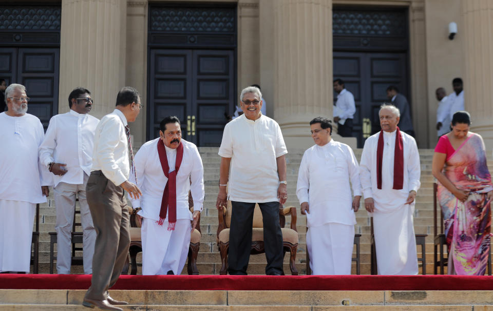 Sri Lankan president Gotabaya Rajapaksa prepares to sit for photographs with his new cabinet members in Colombo, Sri Lanka, Friday, Nov. 22, 2019. Rajapaksa, who was elected last week, said he would call a parliamentary election as early as allowed. The parliamentary term ends next August, and the constitution allows the president to dissolve Parliament in March and go for an election. (AP Photo/Eranga Jayawardena)