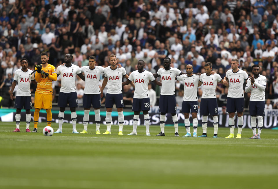 Tottenham players observe a minute of silence in memory of former player and manager Justin Edinburgh prior to the start of the English Premier League soccer match between Tottenham Hotspur and Aston Villa at the Tottenham Hotspur stadium in London, Saturday, Aug. 10, 2019. (AP Photo/Frank Augstein)