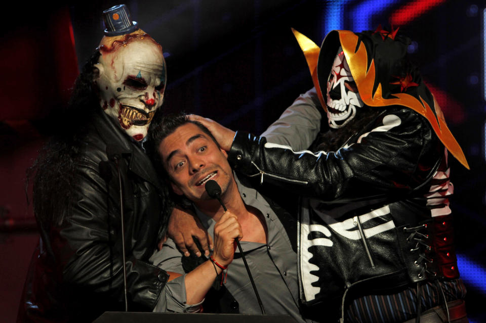 FILE - In this Oct. 6, 2011 file photo, Mexican comedian and host of the MTV Game Awards Omar Chaparro, center, gestures as he is held by professional wrestlers 'La Parka' and 'Diabolic Clown' during the awards ceremony in Mexico City. Chaparro presented his music album "Gori Gori" on Tuesday, July 31, 2012 at a press conference in Mexico City. ( AP Photo/Marco Ugarte, File)