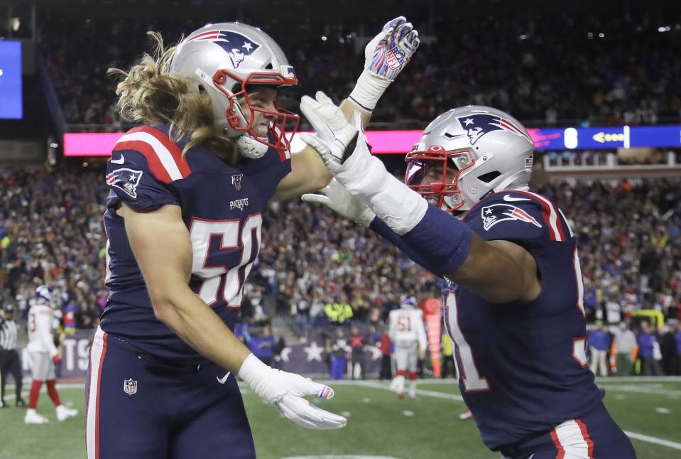 New England Patriots defensive end Chase Winovich, left, celebrates his touchdown with Deatrich Wise after a running back a blocked punt by New York Giants punter Riley Dixon in the first half of an NFL football game, Thursday, Oct. 10, 2019, in Foxborough, Mass. (AP Photo/Elise Amendola)