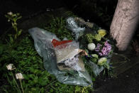 Flowers are placed near the Kyoto Animation building destroyed in an arson attack Thursday, July 18, 2019, in Kyoto, Japan. The blaze started in the three-story building in Japan's ancient capital after the attacker sprayed an unidentified liquid accelerant, police and fire officials said. (AP Photo/Jae C. Hong)