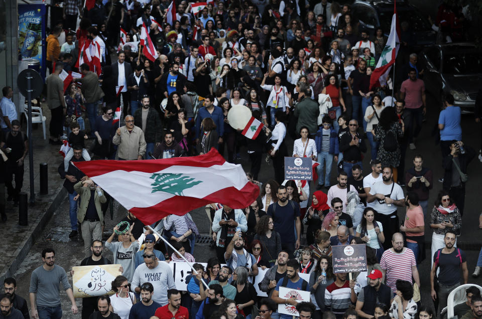 Lebanese protesters wave their national flag, as they march in Beirut, Lebanon, Sunday, Dec. 1, 2019. Protesters have been holding demonstrations since Oct. 17 demanding an end to widespread corruption and mismanagement by the political class that has ruled the country for three decades. (AP Photo/Hussein Malla)