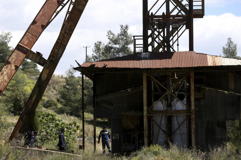 Chief of Cypriot police Zacharias Chrysostomou, second right, walks with Cypriot investigators and police officers at a flooded mineshaft where two female bodies were found, outside Mitsero village near the capital Nicosia, Cyprus, Monday, April 22, 2019. Police on the east Mediterranean island nation, along with the help of the fire service, are conducting the search Monday in the wake of last week's discovery of the bodies in the abandoned mineshaft and the disappearance of the six year-old daughter of one of the victims. (AP Photo/Petros Karadjias)