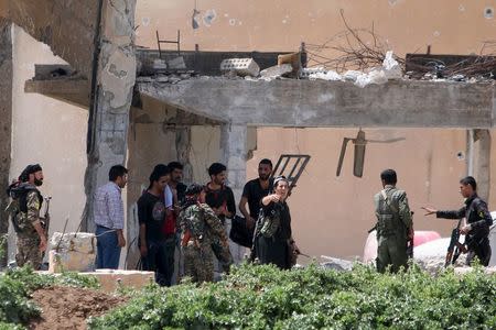 A Kurdish female fighter of the People's Protection Units (YPG) gestures as government forces surrender themselves to Kurdish fighters in the city of Qamishli, Syria April 21, 2016. REUTERS/Rodi Said