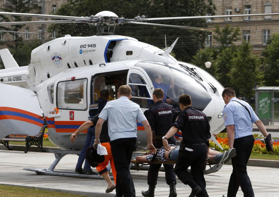 Members of the emergency services carry an injured passenger outside a metro station following an accident on the subway in Moscow July 15, 2014. Five people were killed and nearly 100 were injured when an Moscow underground train went off the rails between two stations during the morning rush hour on Tuesday, the Health Ministry said. (REUTERS/Sergei Karpukhin)