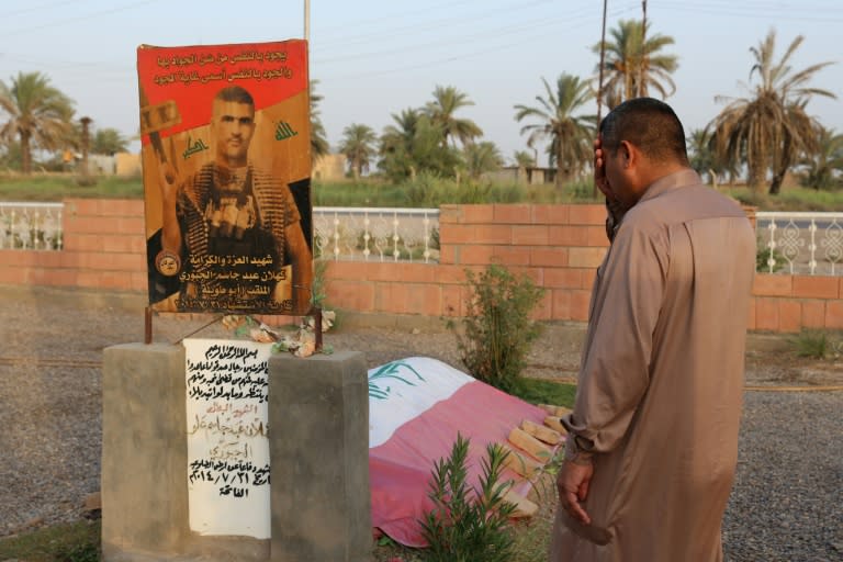 An Iraqi man cries as he visits the grave of a relative, who was killed during battles with Islamic State (IS) group fighters, at a graveyard in the Iraqi town of Dhuluiyah, north of Baghdad