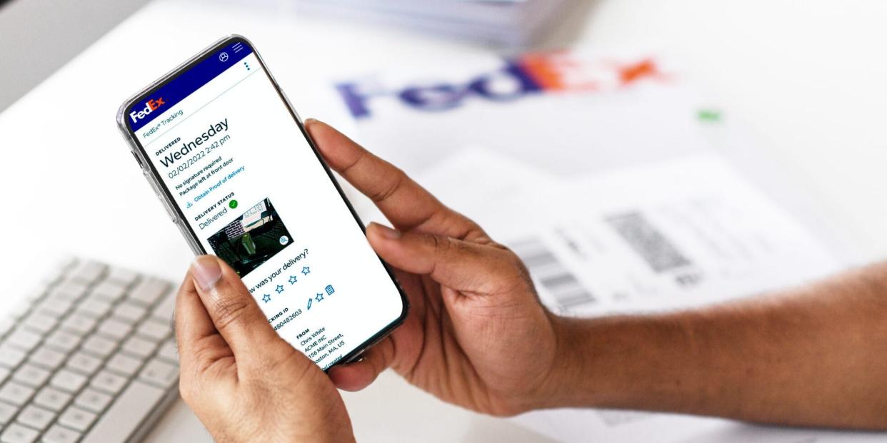 A FedEx customer looks at a picture of their delivered package on a smartphone