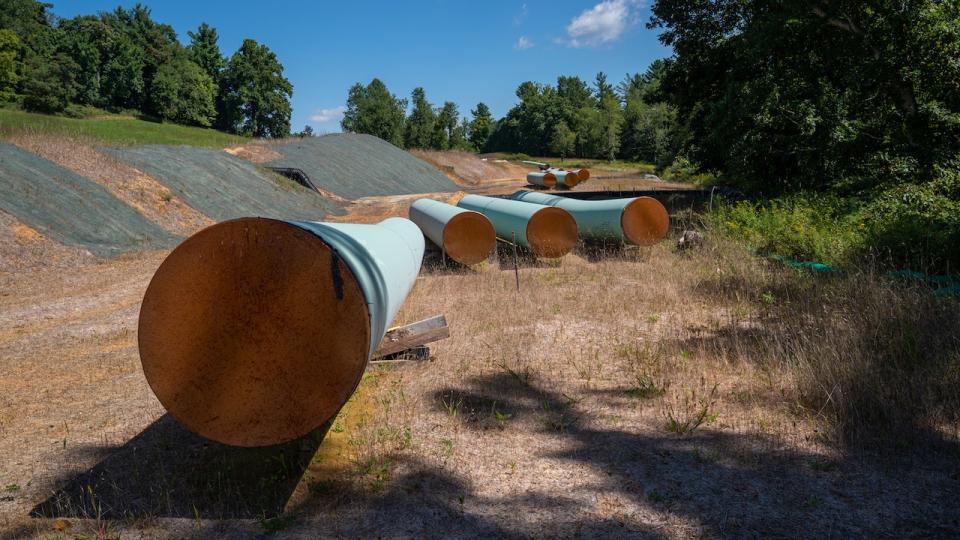 Sections of steel pipe lie on wooden blocks