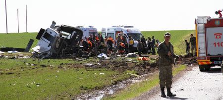 Members of emergency services work next to a damaged military vehicle near Diyarbakir, Turkey February 18, 2016. REUTERS/Cihan News Agency