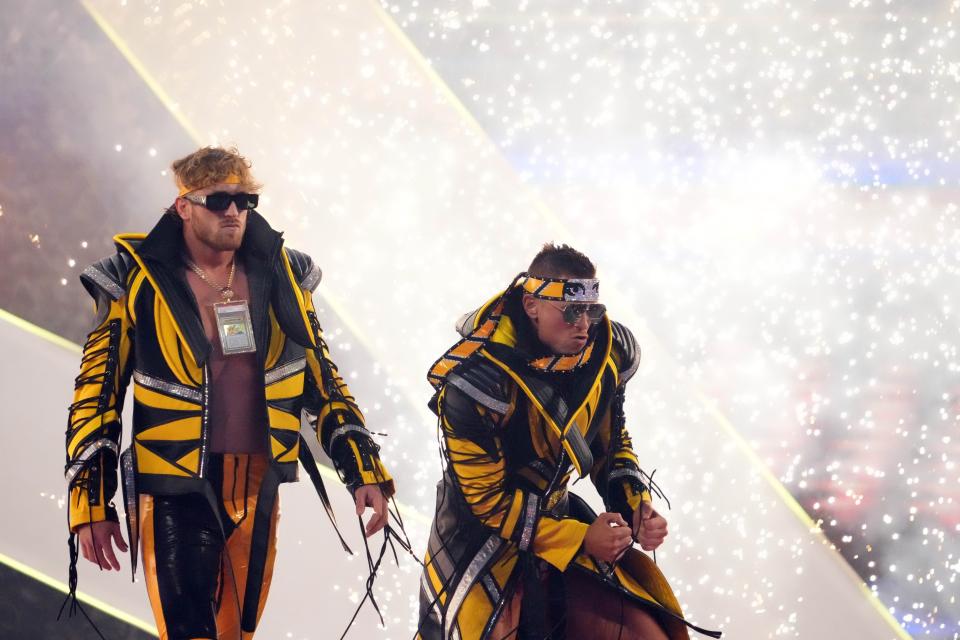 Logan Paul (left) and The Miz enter the arena during WrestleMania at AT&T Stadium in Arlington, Texas on April 2, 2022. Paul is wearing a Pikachu card worth more than $5 million as a necklace.