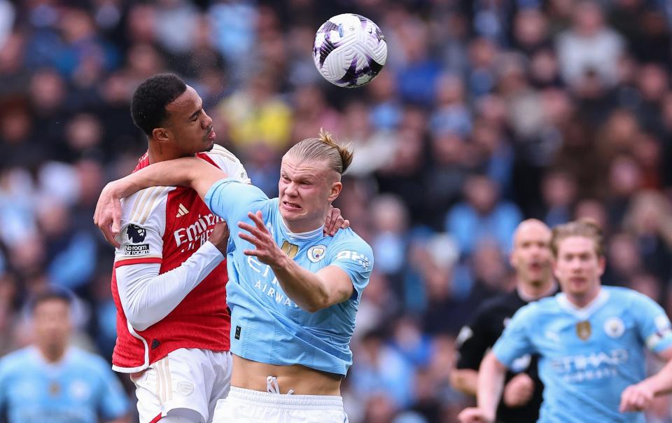 William Saliba of Arsenal wins a header against Erling Haaland of Manchester City during the Premier League match between Manchester City and Arsenal FC at Etihad Stadium on March 31, 2024 in Manchester, England