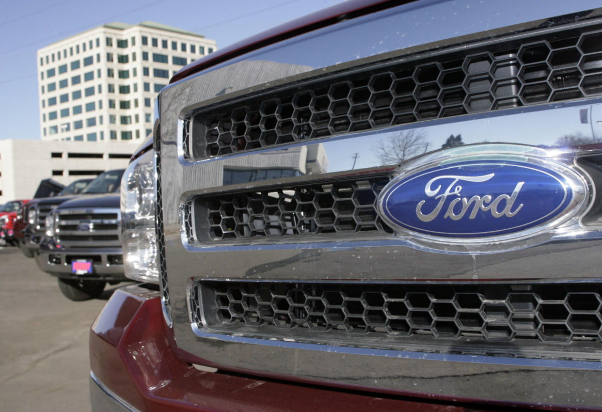 The company logo shines off the grille of an unsold 2007 F350 pickup truck in a long line of unsold pickups on the lot of a Ford dealership in Denver on Sunday, Dec. 10, 2006. (AP Photo/David Zalubowski)