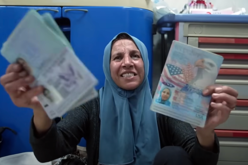 Noha Abuolba holds up her American passport in a Gaza hospital after a car carrying her and her daughters is hit by an apparent airstrike (Al Jazeera)