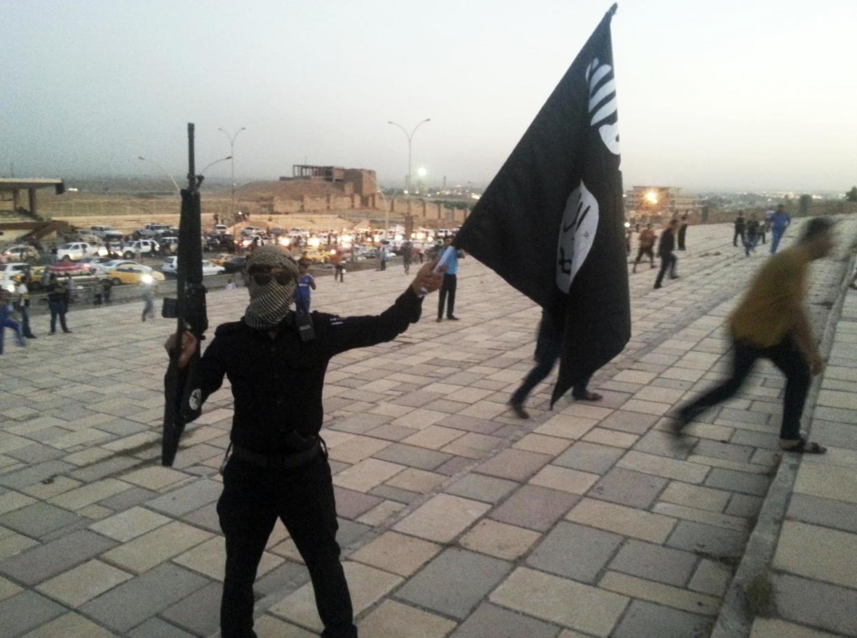 An Isis fighter holds up the group's flag after seizing the Iraqi city of Mosul on 23 June 2014. A seven-month long US-led coalition effort to free the city has almost succeeded in its goal: REUTERS