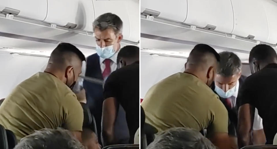 A flight attendant and passengers restrain a child on a plane. Source: CBS LA