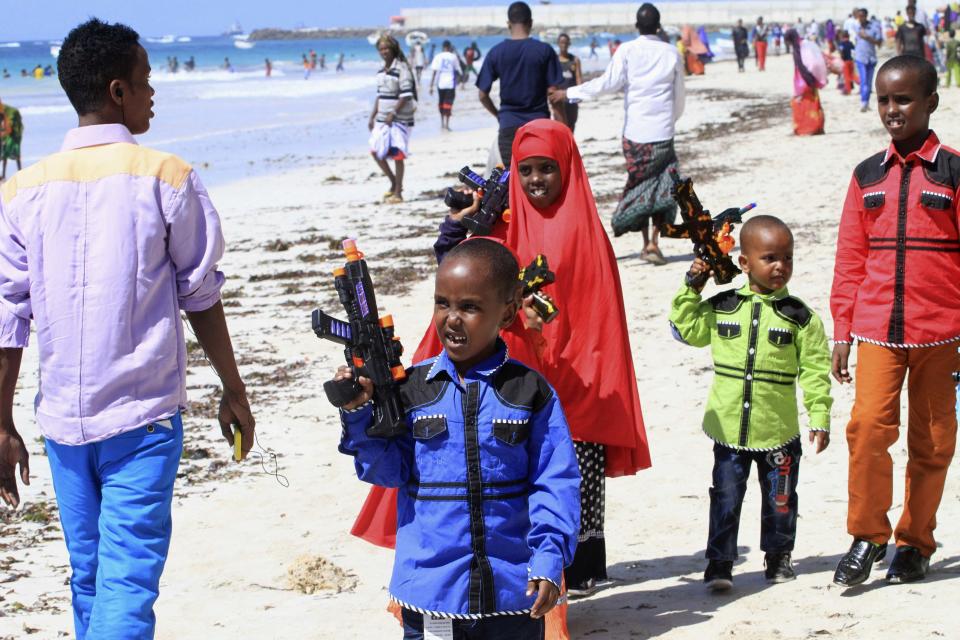 Somali children stroll along the beach holding toy guns during the Muslim festival of Eid-al-Adha in capital Mogadishu