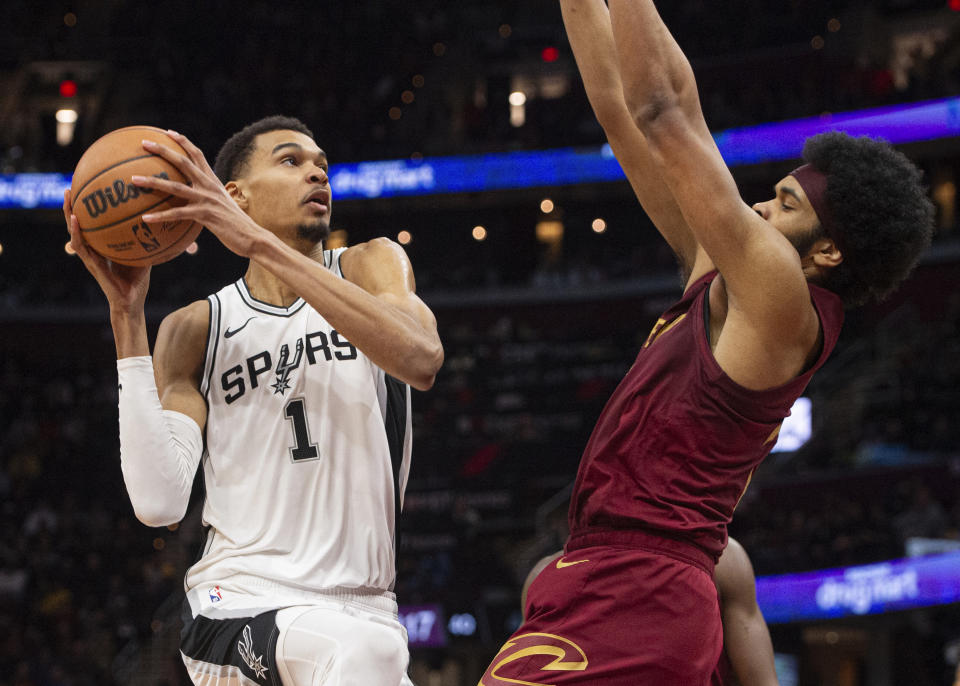 San Antonio Spurs' Victor Wembanyama (1) drives to the basket as Cleveland Cavaliers' Jarrett Allen, right, defends during the second half of an NBA basketball game in Cleveland, Sunday, Jan. 7, 2024. (AP Photo/Phil Long)