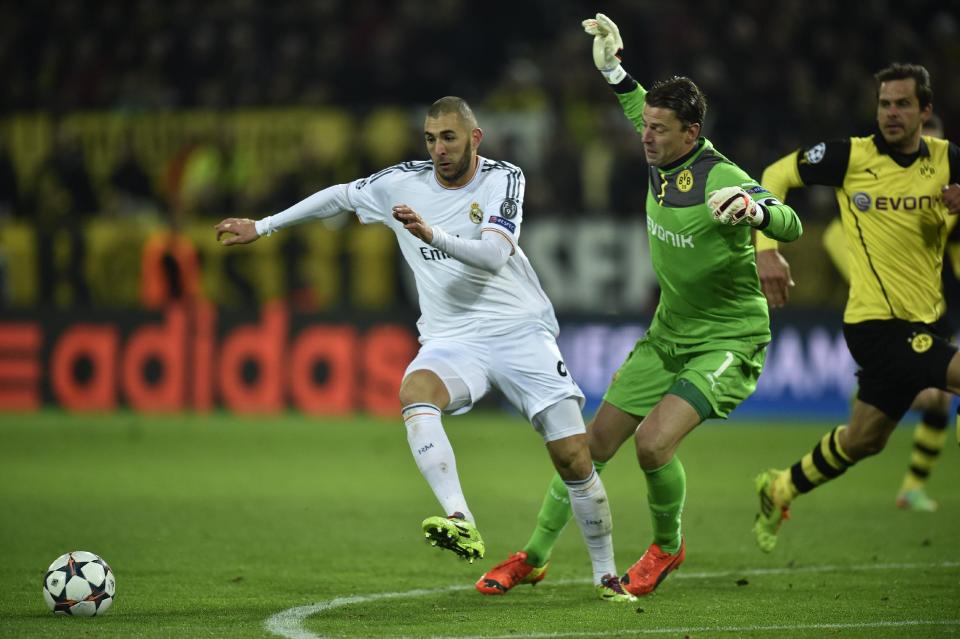 Real's Karim Benzema fights for the ball next to Dortmund goalkeeper Roman Weidenfeller during the Champions League quarterfinal second leg soccer match between Borussia Dortmund and Real Madrid in the Signal Iduna stadium in Dortmund, Germany, Tuesday, April 8, 2014. (AP Photo/Martin Meissner)