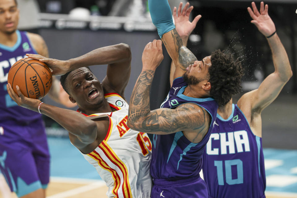 Atlanta Hawks center Clint Capela (15) looks to pass as he drives into Charlotte Hornets forward Miles Bridges during the first half of an NBA basketball game in Charlotte, N.C., Sunday, April 11, 2021. (AP Photo/Nell Redmond)