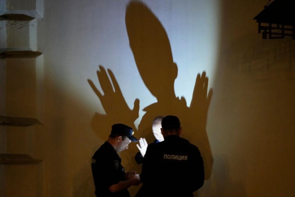 Police officers check documents of a man in central Moscow, Russia, on June 25.<span class="copyright">Dmitri Lovetsky—AP</span>