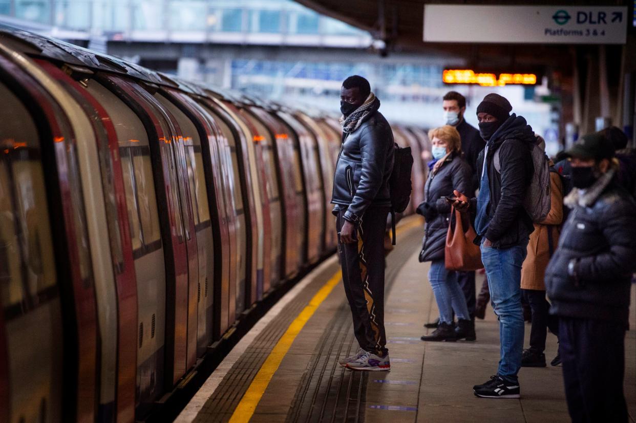 Commuters getting on a Jubilee Line Underground train at Canning Town station (PA)