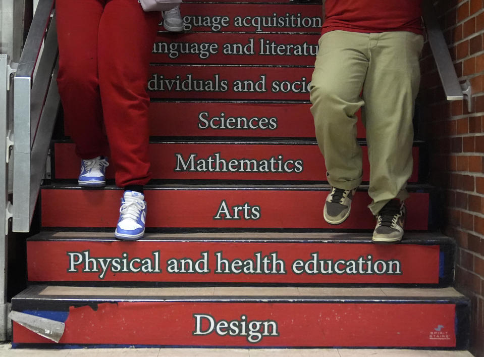 Students at the Wells Preparatory Elementary School make their way to the cafeteria past reminders of the education and subjects they are receiving on Friday, March 8, 2024, in Chicago. In Chicago Public Schools, the average reading score went up by the equivalent of 70% of a grade level from 2022 to 2023. Math gains were less dramatic, with students still behind almost half a grade level compared to 2019. Chicago officials credit the improvement to changes made possible with nearly $3 billion in federal relief. (AP Photo/Charles Rex Arbogast)