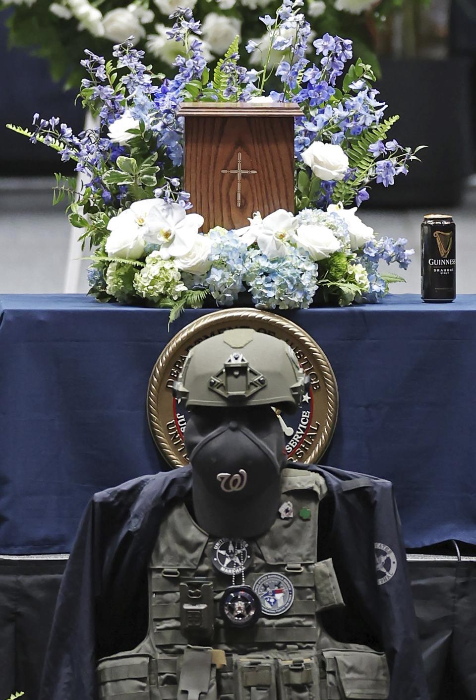 U.S. Marshal Thomas Weeks Jr.'s, gear and body stand during a memorial to the slain officer at Bojangles Coliseum in Charlotte, NC on Monday, May 6, 2024. U.S. Marshal Thomas Weeks Jr., died during a standoff with a gunman on Monday, April 29. (Jeff Siner/The Charlotte Observer via AP)