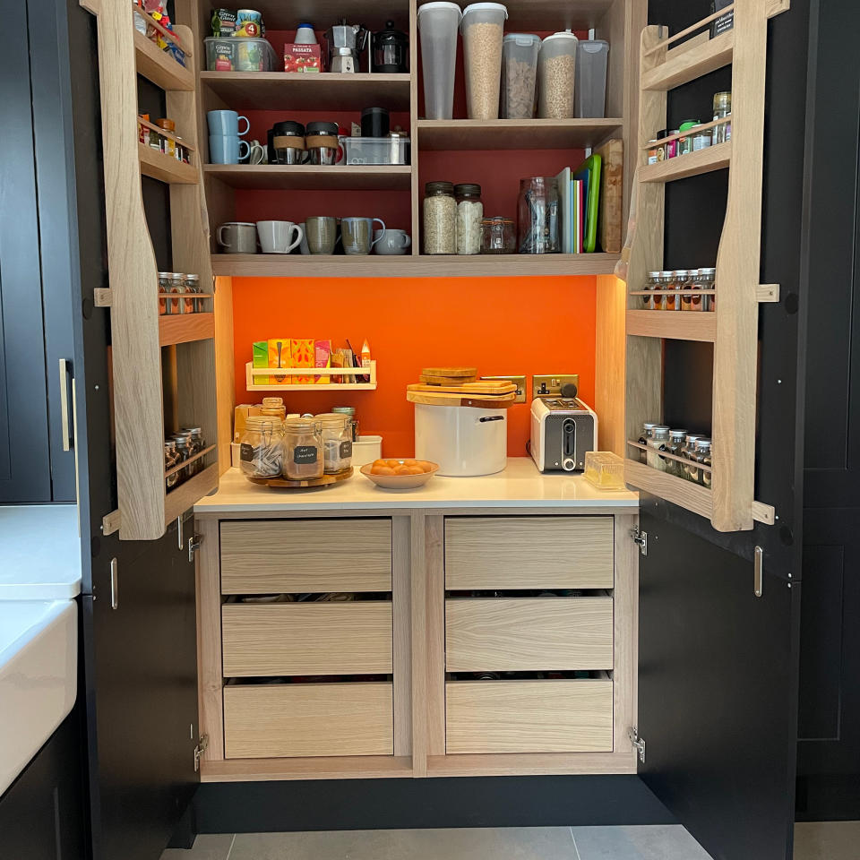 Open built-in kitchen pantry with drawers and shelves and internal lights