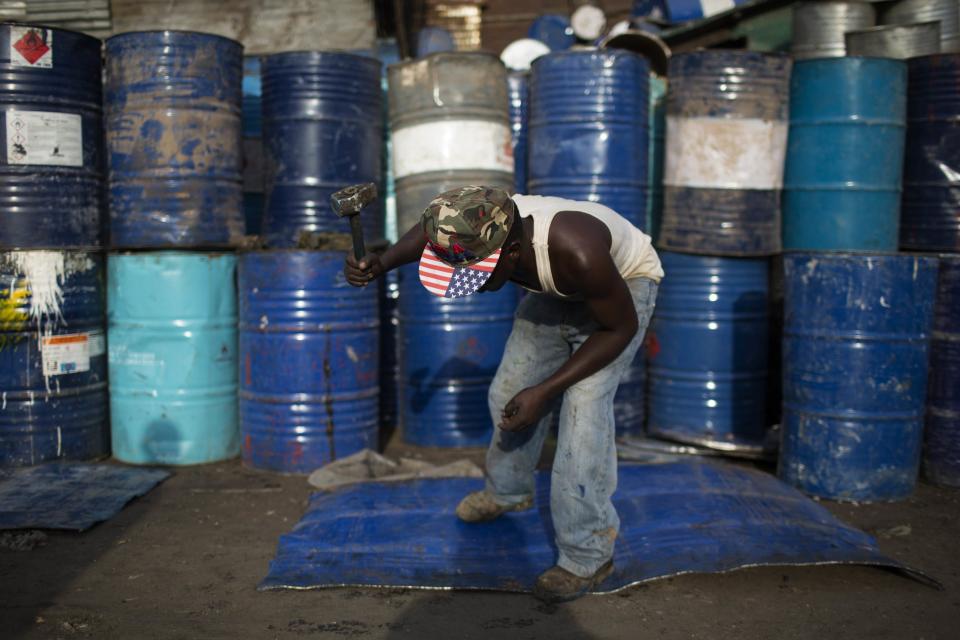 Un hombre golpea con un martillo un barril de petróleo con el objetivo de convertirlo en una lámina de metal que puede usarse como un material reciclado, en Kamukunji, Nairobi.