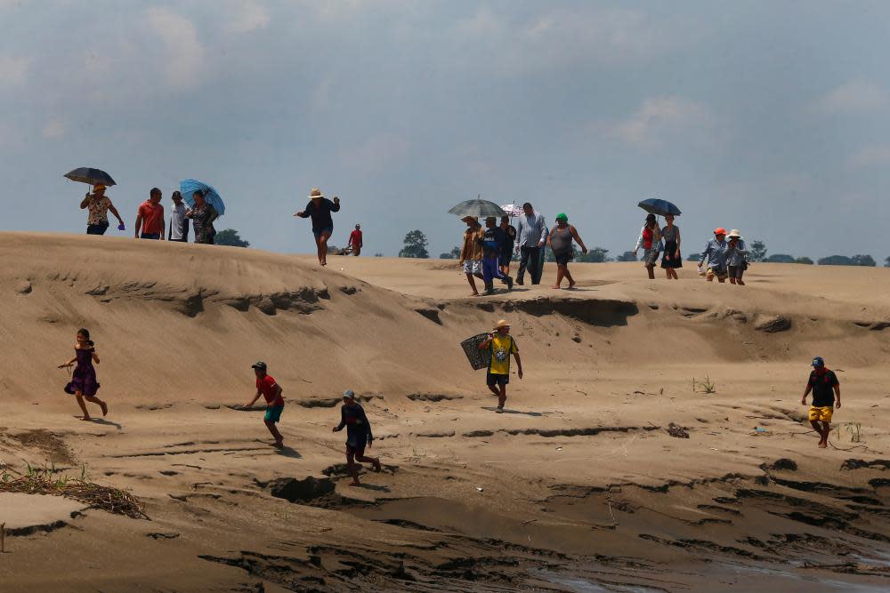 People walk along a dried-out river