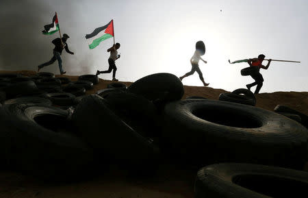 FILE PHOTO - Palestinian protesters run during clashes with Israeli troops at Israel-Gaza border, in the southern Gaza Strip April 5, 2018. REUTERS/Ibraheem Abu Mustafa