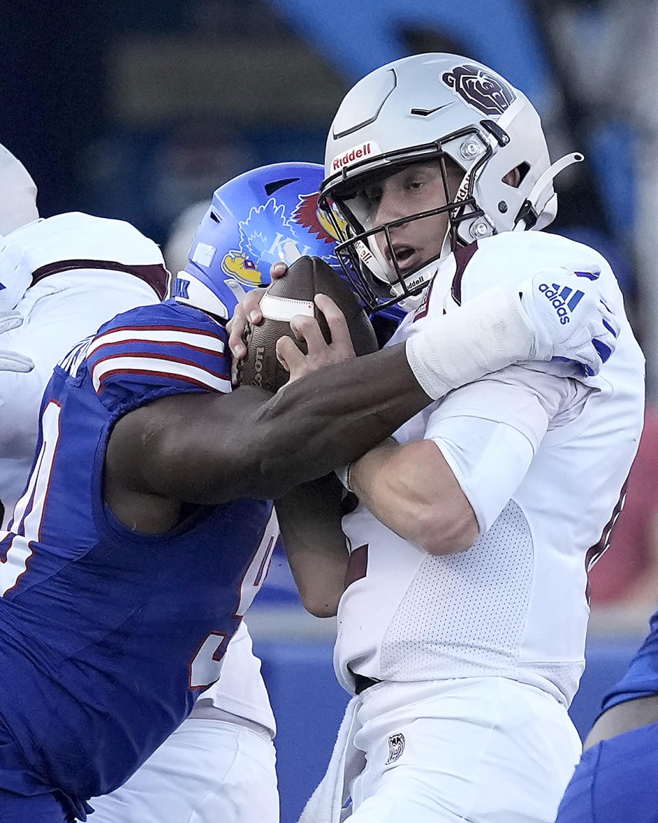 Missouri State quarterback Jacob Clark, right, is sacked by Kansas defensive lineman Jereme Robinson during the first half of an NCAA college football game Friday, Sept. 1, 2023, in Lawrence, Kan. (AP Photo/Charlie Riedel)