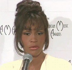 Whitney Houston wide eyed and then shaking her head