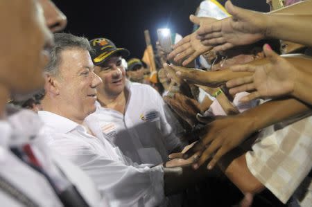 Colombia's President Juan Manuel Santos (C) and Vice President German Vargas Lleras shake hands with citizens during a major demonstration in favour of the agreement, in Barranquilla, Colombia, September 27, 2016. Colombian Presidency/Handout via Reuters.