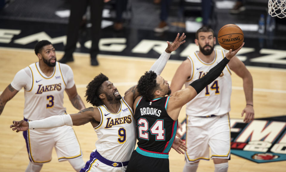 Memphis Grizzlies guard Dillon Brooks (24) shoots past Los Angeles Lakers guard Wesley Matthews (9) as forward Anthony Davis (3) and center Marc Gasol (14) looks on during the first half of an NBA basketball game Sunday, Jan. 3, 2021, in Memphis, Tenn. (AP Photo/Wade Payne)