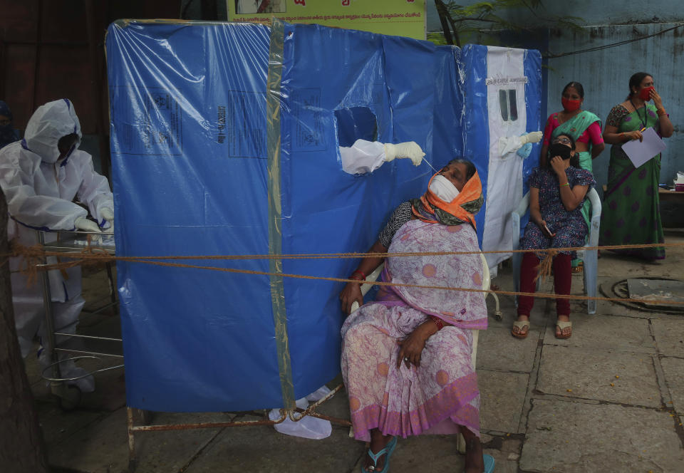 A health worker takes a nasal swab sample to test for COVID-19 in Hyderabad, India, Saturday, Aug. 22, 2020. India has the third-highest caseload after the United States and Brazil, and the fourth-highest death toll in the world. (AP Photo/Mahesh Kumar A.)