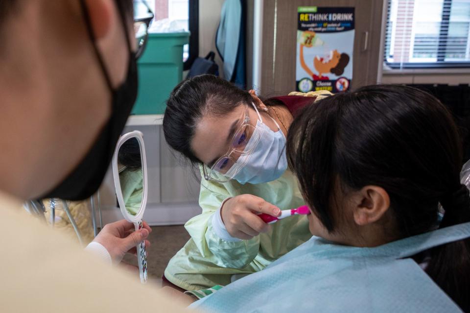 Jessica Oh, 33, a fourth-year dental student with the University of Detroit Mercy School of Dentistry Dental Clinic, demonstrates proper hygiene instructions to 10-year-old Milagro Fernandez-Rivera inside the Titans for Teeth Mobile Clinic at the Munger Elementary-Middle School in Detroit on April 26, 2023.