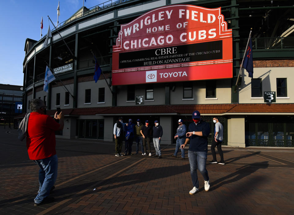 FILE - Chicago Cubs fans stand outside of Wrigley Field before a baseball game against the Minnesota Twins in Chicago, in this Sunday, Sept. 20, 2020, file photo. Thousands of fans of the Chicago Cubs and the Chicago White Sox will get to see their teams play in person this season, Mayor Lori Lightfoot announced on Monday, March 9, 2021. In a news release, Lightfoot said each team will be limited to 20% capacity. (AP Photo/Matt Marton, File)