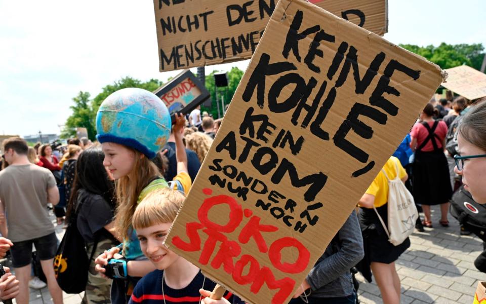 A demonstrator in Berlin holds up a placard reading 