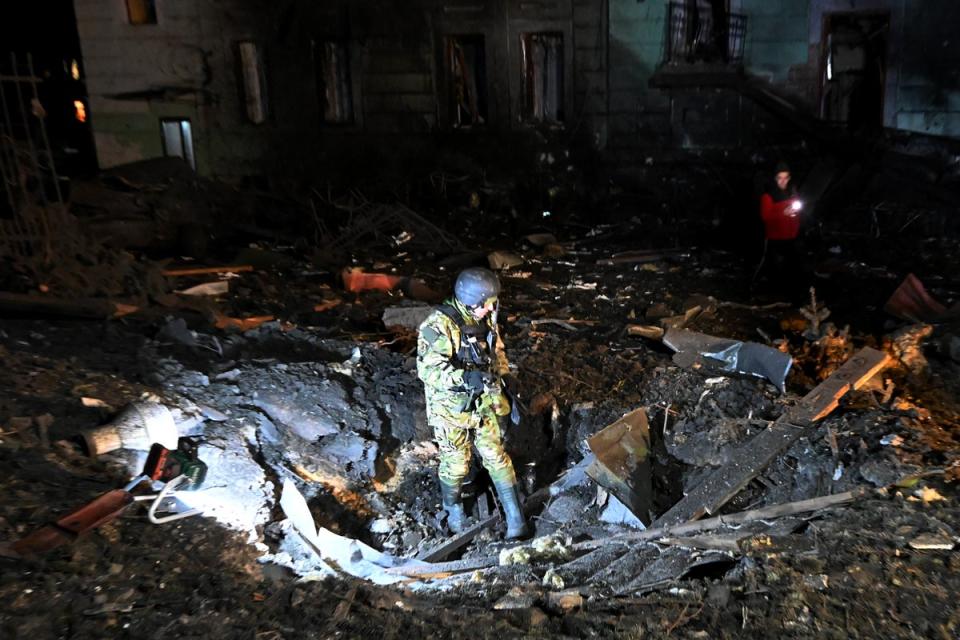 An explosives expert inspects a crater following a missile attack in Kharkiv (AFP via Getty Images)