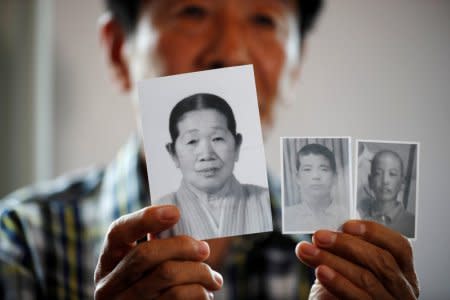 A man selected as a participant for a reunion shows pictures of his deceased mother and little brothers living in North Korea, at a hotel used as a waiting place in Sokcho, South Korea, August 19, 2018.    REUTERS/Kim Hong-Ji