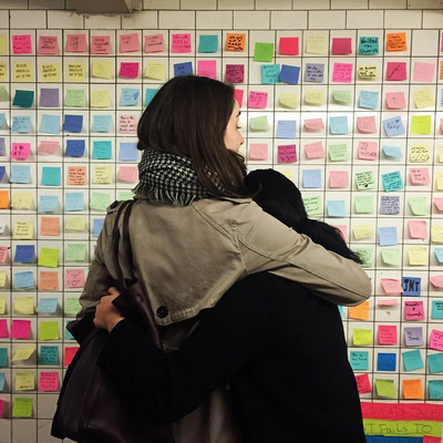 Neoyorquinos leyendo los mensajes de protesta que la gente ha dejado en el metro.