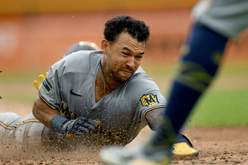 Milwaukee Brewers center fielder Blake Perkins (16) slides head first into home plate to score a run against the Detroit Tigers in the sixth inning at Comerica Park in Detroit on Saturday, June 8, 2024.