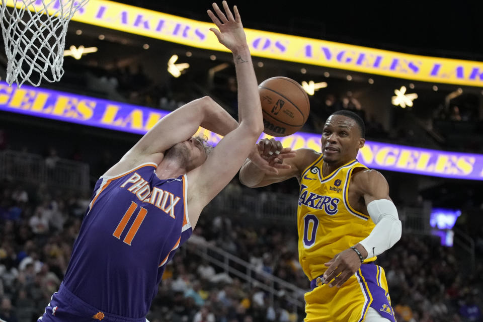 Los Angeles Lakers guard Russell Westbrook (0) fouls Phoenix Suns center Jock Landale (11) during the first half of a preseason NBA basketball game Wednesday, Oct. 5, 2022, in Las Vegas. (AP Photo/John Locher)